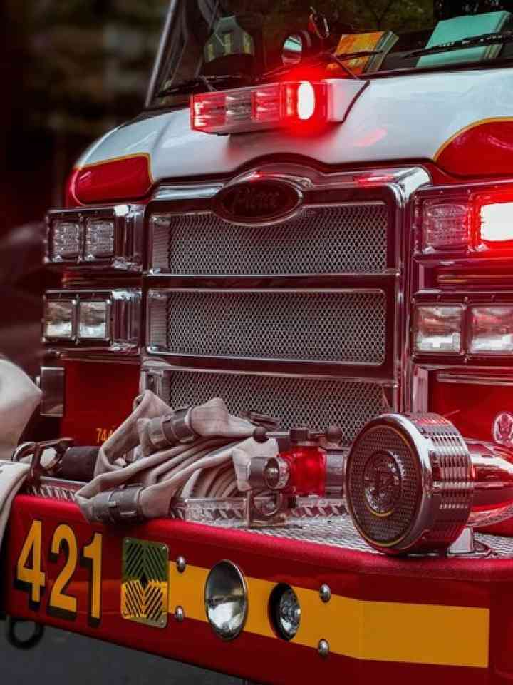 A fire truck carrying first responders and displaying emergency lights